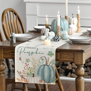 Close-up of Hello Pumpkin table runner with autumn leaf prints on dark wood table