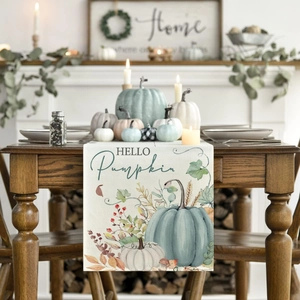 Detail of fall table runner featuring light blue pumpkins and maple leaves on wood