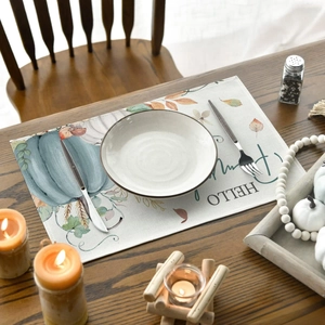 Detail of Hello Pumpkin table runner with autumn leaves on rustic wooden dining table