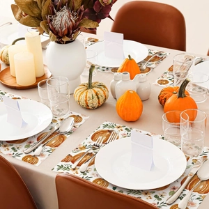 Close-up of Thanksgiving table mat with orange pumpkin and floral print patterns