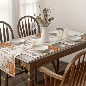 Macro detail of pumpkin and maple leaf printed table runner with matching placemats