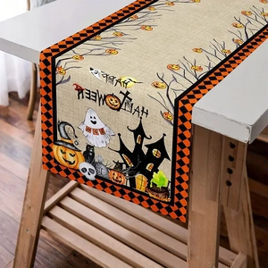 Detail of Halloween table runner showing pumpkin, ghost and black cat prints on linen fabric