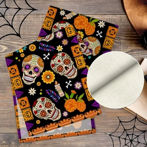 Macro detail of Dia de los Muertos table mat featuring sugar skull prints on woven canvas