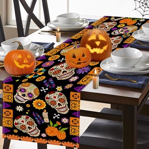 Close-up of Halloween table runner with Mexican sugar skull print on dark wood table