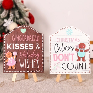 Detail of Christmas gingerbread wooden signs with holiday wishes and tripod stands