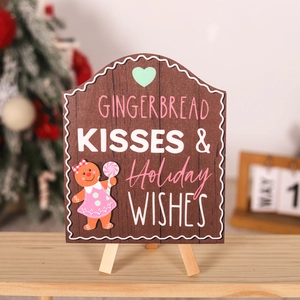 Close-up of wooden Gingerbread Kisses holiday sign with festive character and tripod stand