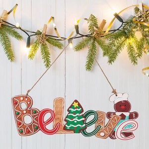 Close-up of wooden Believe Christmas ornament with gingerbread man and festive pine tree