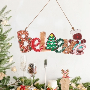 Hanging wooden gingerbread man ornament with Believe text on a festive Christmas tree background
