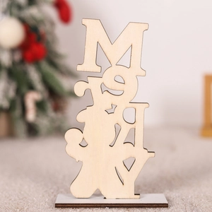 Close-up of laser-cut wooden Merry sign on table with blurred Christmas tree background