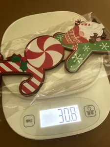 Close-up of wooden Christmas JOY sign with gnome motif on a digital weight scale