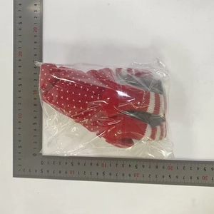 Vue détaillée des gants de Noël tricotés rouges et blancs avec motifs de flocons de neige