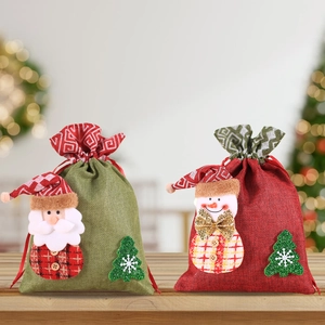 Detail of burlap Christmas gift bags with 3D Santa and snowman patches on wood table