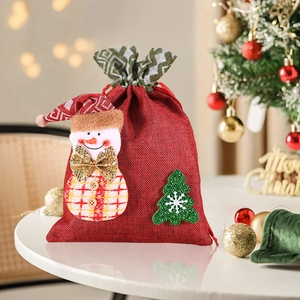 Detailed view of red burlap Christmas gift bag with snowman and tree patchwork design