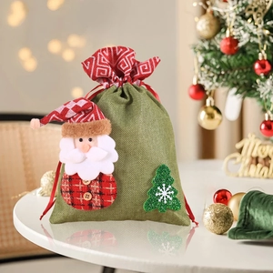 Detail of green burlap Christmas gift bag with 3D Santa and festive red ribbon drawstring