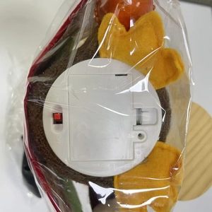 Close-up of the harvest turkey doll base showing battery compartment and CE certification