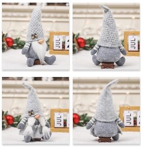 Close-up of grey faceless Christmas gnomes with knit hats and bell details on wooden stools