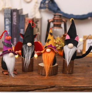 Close-up of four Halloween gnome plush toys with pumpkin, bat and spider motifs