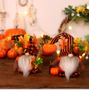 Detail of harvest gnomes with striped hats, maple leaves, and berries on wooden surface