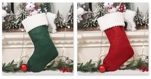 Detail of red and green velvet Christmas stockings hanging with knitted white cuffs