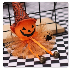 Close-up of Halloween orange pumpkin ghost pendant with witch hat and small bells
