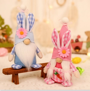 Detail of plush Easter gnomes with rabbit ears and carrot embroidery on a wooden bench