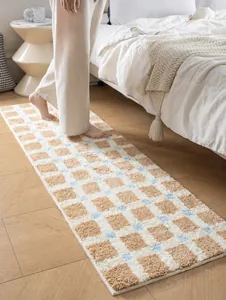 Nahaufnahme der weichen beflockten Bettvorleger mit beige-blauem Schachbrett-Muster