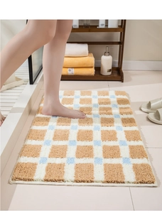 Dettaglio del tappeto da bagno a scacchi con morbida texture floccata e bordi rifiniti