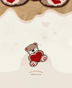 Détail de la texture floquée douce d'un tapis ours mignon avec un coeur rouge