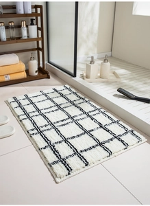 Close-up of plush white checkered bathroom rug texture with absorbent microfiber fibers