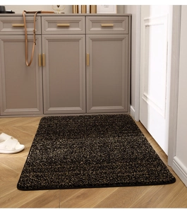 Detalle de alfombra de entrada gruesa con textura de arena dorada sobre madera