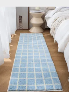 Close-up of soft blue checkered bath mat showing thick flocked texture and anti-slip backing