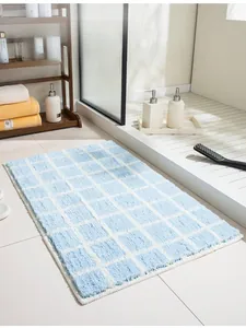Close-up of blue and white checkered plush bath mat in a modern shower room setting