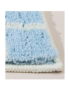 Detailed macro view of plush checkered bath mat showing blue and white fluffy texture