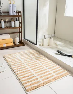 Detail of soft striped bedside rug with plush texture and high-quality stitched edges