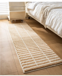 Detail of striped flocked runner rug with thick texture on light wood floor