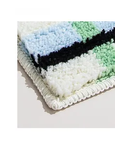 Gros plan du tapis de bain touffeté aux motifs géométriques colorés et fibres douces épaisses