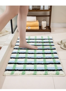 Détail du tapis de bain à carreaux verts avec texture douce absorbante et envers antidérapant