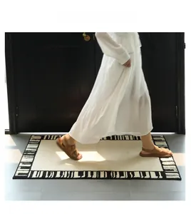 Detail view of cream rectangle rug with black and white geometric border in home setting