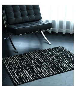 Detailed close-up showing the woven texture and white geometric dots on the black floor mat