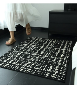Detailed texture of black and white faux wool rug with abstract dash patterns