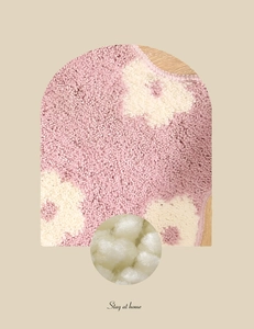 Close-up of thick plush pink bath mat showing soft floral fibers and absorbent texture