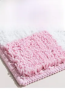 Close-up of thick pink and white floral bath mat showing dense fibers and lock-stitched edges