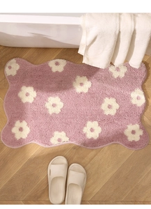 Detail of pink floral checkered bath mat with soft flocking and wavy scallop edges