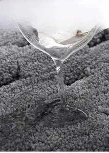 Close-up of dark grey chenille bathroom mat demonstrating rapid water absorption