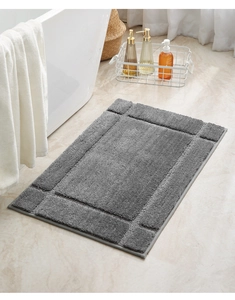 Macro detail of dark grey absorbent bath mat showing thick plush texture and non-slip surface