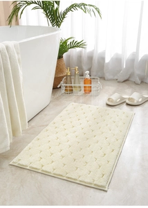 Detail van beige absorberende badmat met antisliptextuur op marmeren badkamervloer
