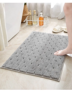 Detail van de grijze absorberende badmat met reliëfstructuur en antislip afwerking