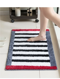 Close-up of plush absorbent bath mat with black and white stripes and red accents