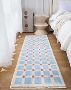 Detail of soft blue and white checkered bedroom runner rug with plush texture and pink accents