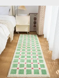 Close-up of soft green and white checkered plush bedside rug with pink accent details